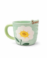 Green mug with a floral design and 'Sunny' text on a white background
